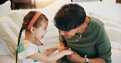 Buy stock photo Happy, child and grandmother laughing on couch together with love, care and holding hands in lounge. Family, support and senior woman with girl in living room bonding together with secret or joke