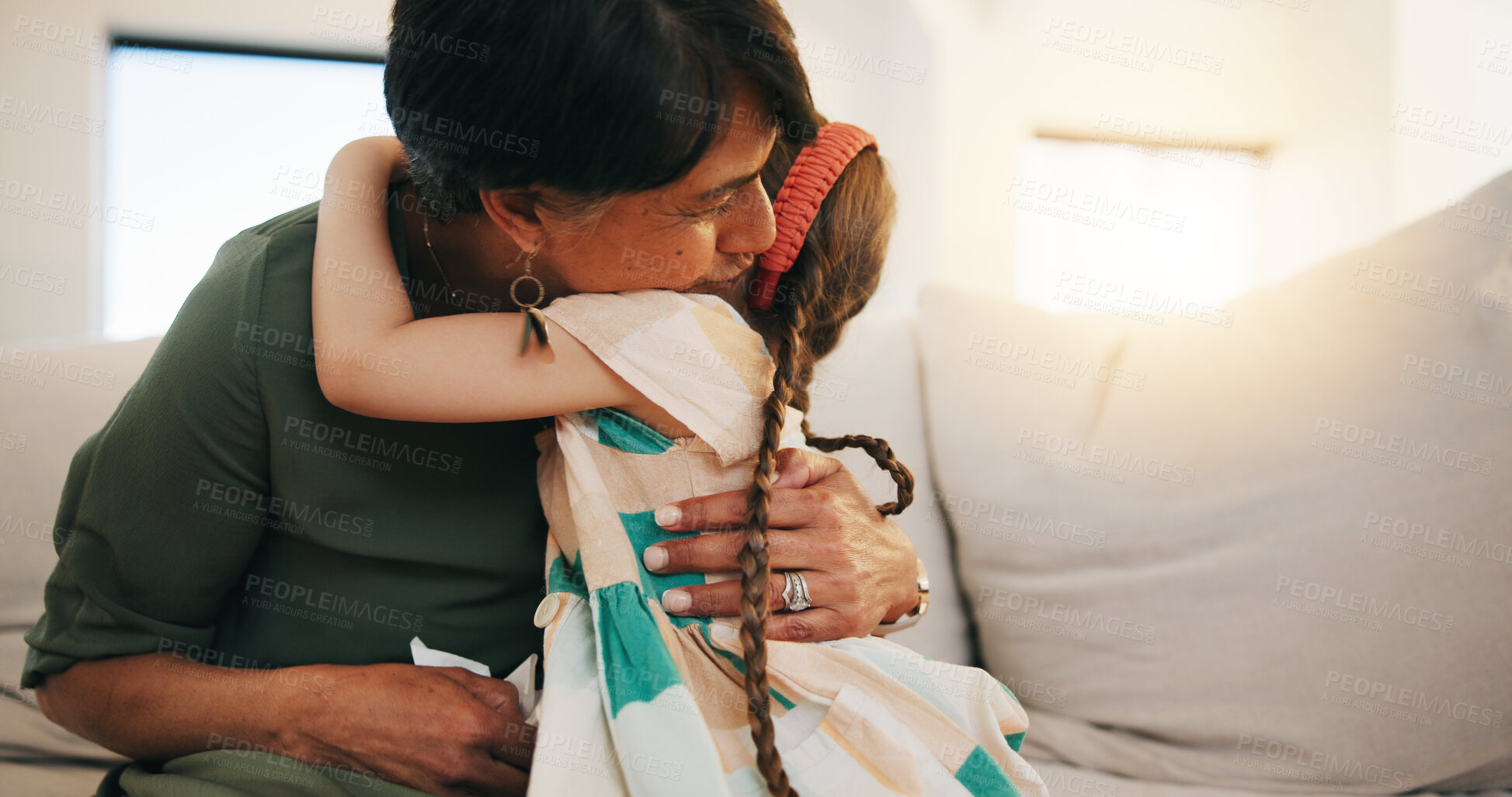 Buy stock photo Family, love and girl hugging her grandmother on a sofa in the living room of their home during a visit together. Trust, care and security with a senior woman embracing her grandchild in an apartment