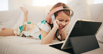 Buy stock photo Happy little girl, tablet and headphones on sofa for elearning, entertainment or streaming at home. Female person, child or kid smile on technology in relax for movie, education or learning at house