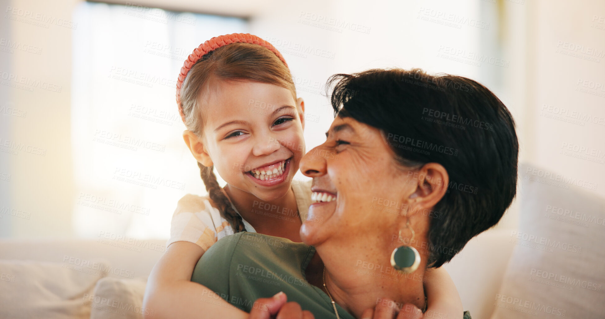 Buy stock photo Child, grandmother and hug on sofa for laugh bonding, relax connection in retirement. Girl, old woman and embrace on couch for holiday rest or together in lounge for funny joke, love support or care