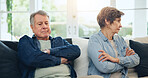 Senior, couple and stress with divorce and fight on sofa in living room of home with anger and silence. Elderly, man or woman with argument, upset and frustrated on couch in lounge of house or ignore