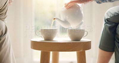 Buy stock photo Pour, pot and hands with tea cup in morning, home and closeup on drink, steam and table. Hot, beverage and person with hospitality, service and drinking in the afternoon with guest in living room