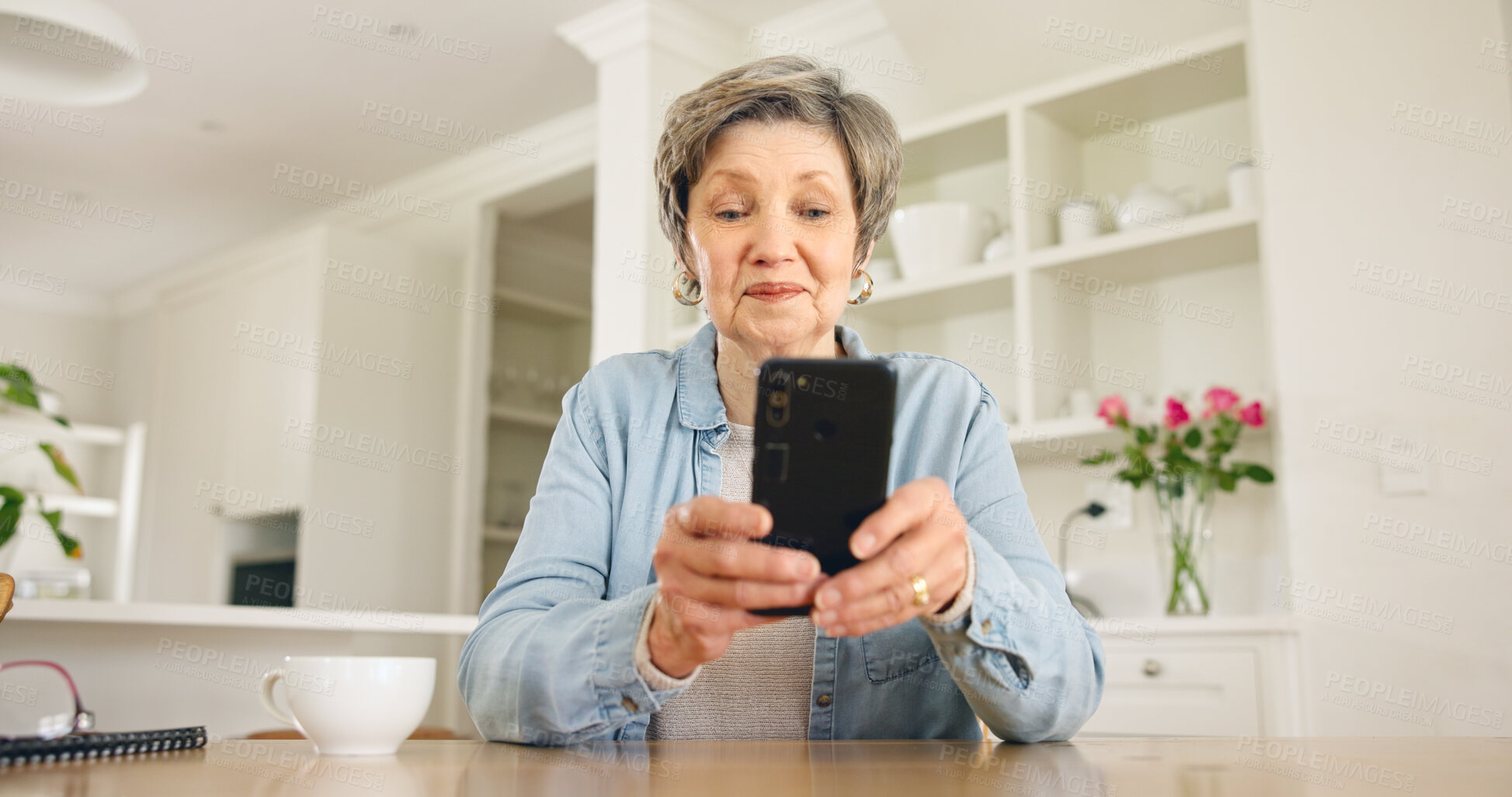 Buy stock photo Senior woman typing on smartphone in home at table for social media, reading email or chat. Elderly person on mobile phone app, search internet and communication on digital technology in retirement