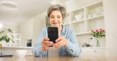 Buy stock photo Happy senior woman, phone and social media in relax for communication or networking in kitchen at home. Mature female person smile on mobile smartphone for online chatting, texting or search at house