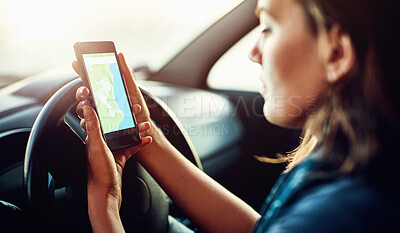 Buy stock photo Cropped shot of a young woman using her cellphone to find directions while driving