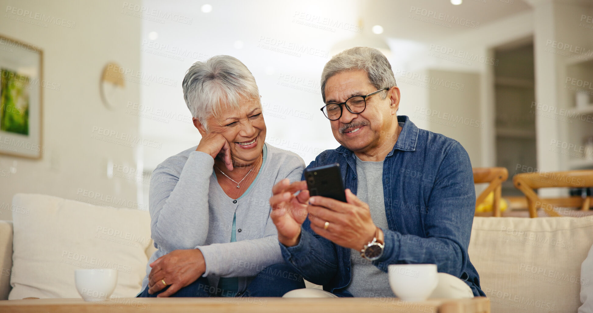 Buy stock photo Senior couple, smartphone and social media with smile, conversation and living room sofa. Grandparents, technology and communication with family, man and woman in retirement, happy and connection