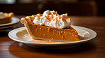 Traditional, pumpkin pie and thanksgiving dessert for festive holiday, celebration or dinner, topped with whipped cream. Delicious, rustic and tasty closeup of a slice of home-made pastry on a plate