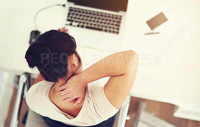 Buy stock photo High angle shot of a young businesswoman holding her neck in discomfort while working at home