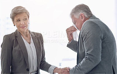 Buy stock photo Cropped shot of an ill businessperson shaking hands with an associate and sneezing in the office