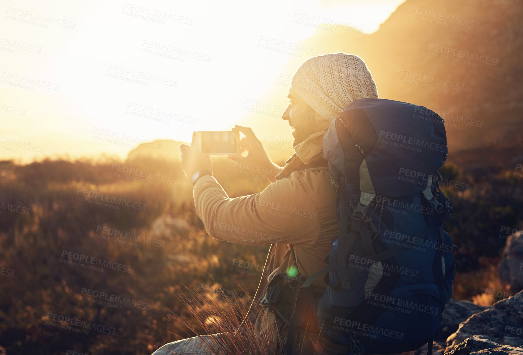 Buy stock photo Shot of a hiker on top of a mountain capturing pictures of the view