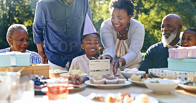Young boy, birthday cake and wish in garden for party, happy family and celebration in nature. Black people, smile and cream dessert with fun with bonding, excited and special kid event in backyard