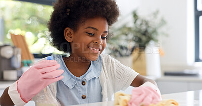 Child, gloves and happy in kitchen for cleaning, learning housekeeping as youth in home. Young girl, smile and cloth with sanitizer to shine counter and disinfectant surface in house with detergent