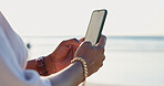 Closeup, beach and person with a smartphone, typing and connection with vacation, internet and contact. Outdoor, hands and traveller with a cellphone, seaside and holiday with message, app or texting