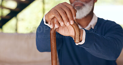 Hands, walking stick and a senior man on a sofa in the living room of his home for nostalgia closeup. Balance, cane or mobility aid and an elderly person with a disability in his apartment to relax