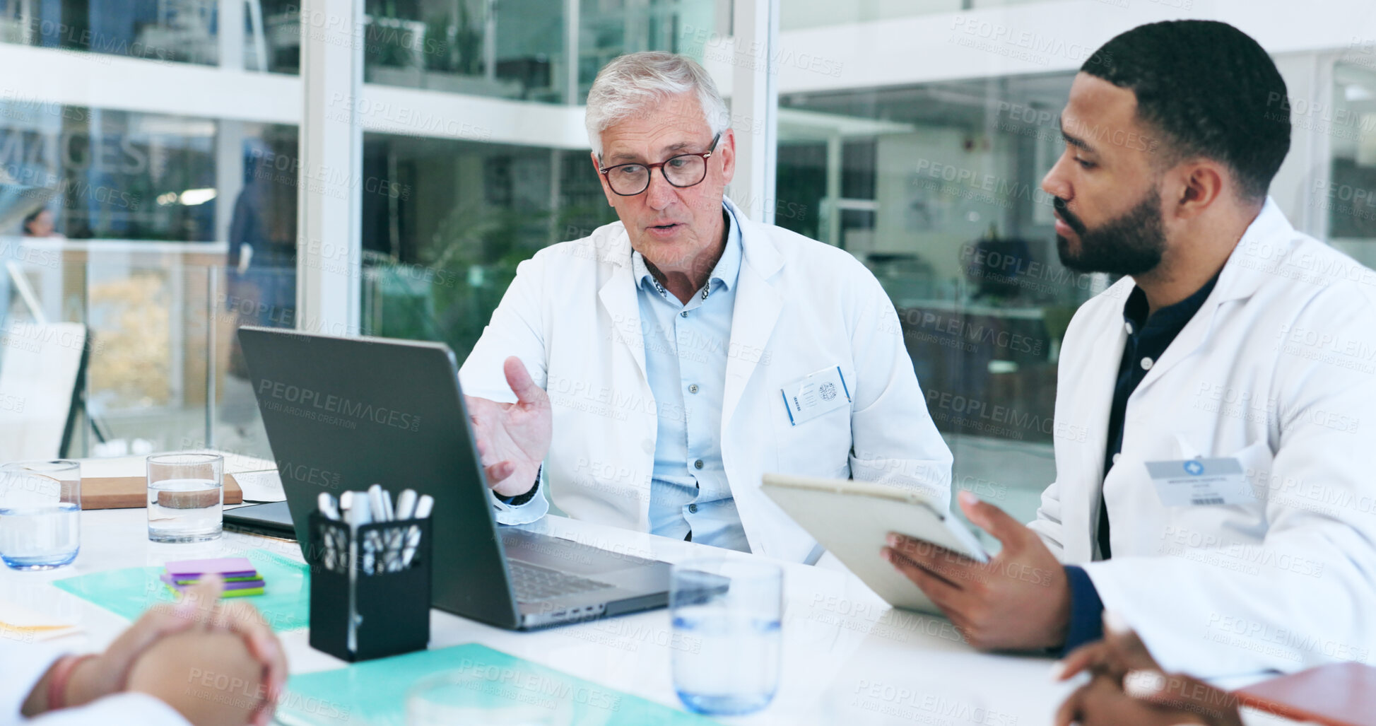 Buy stock photo Laptop, doctor and team in meeting at hospital, discussion and planning, conversation or training. Technology, medical group and people at table in communication, healthcare and collaboration online