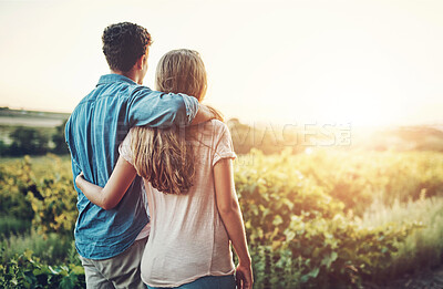 Buy stock photo Rearview shot of an affectionate young couple looking over their crops on the farm