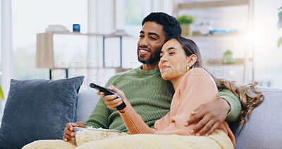 Buy stock photo Couple, watching tv and popcorn on living room sofa for smile, hug or relax with remote for choice, show or film. Man, woman and happy together for embrace, movie or streaming on lounge couch in home