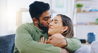 Buy stock photo Kiss, hug and couple on a sofa with love, relax and security at home bonding, hanging out or chilling. Happy, support and people in a living room with trust, commitment and gratitude, care or romance