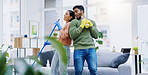 Happy couple, dancing and singing while cleaning living room together for fun disinfection or hygiene at home. Man and woman enjoying housekeeping, germ and bacteria removal in lounge at house