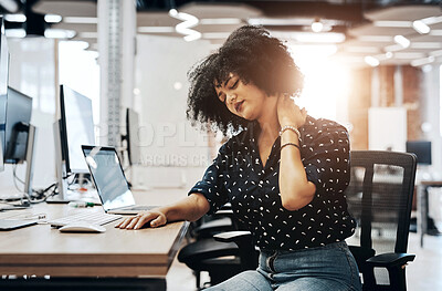 Buy stock photo Shot of a young female designer experiencing neck pain and discomfort while sitting at her office desk