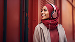 Muslim, woman and listening to music in city for entertainment, podcast and meditation. Beautiful, confident and happy student with fashion style, headphones and inspiration radio song on urban walk