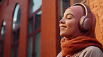 Muslim, woman and listening to music in city for entertainment, podcast and meditation. Beautiful, confident and happy student with fashion style, headphones and inspiration radio song on urban walk