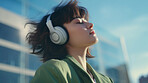 Young, woman and listening to music in city for entertainment, podcast and meditation. Beautiful, confident and happy student with fashion style, headphones and inspiration radio song on urban walk