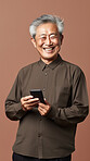 Senior asian man, portrait and phone for social media app, internet and website on color background mockup. Face, smile and happy pensioner with mobile technology for influencer blog post in house with bokeh background