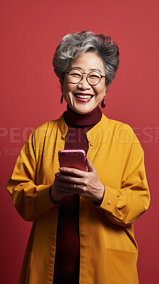 Buy stock photo Senior asian woman, phone and glasses in mock-up with device music, social media video or funny meme. Happy pensioner laughing for audio tech, internet post and cellphone in studio with vibrant colour