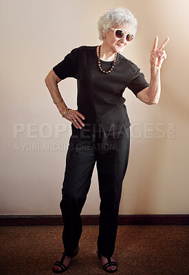 Buy stock photo Shot of a cool senior woman wearing sunglasses and showing a peace gesture