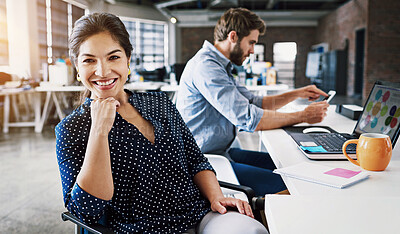 Buy stock photo Portrait of a young designer working in an office with her colleague in the background
