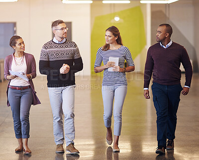 Buy stock photo Shot of a group of coworkers walking alongside each other