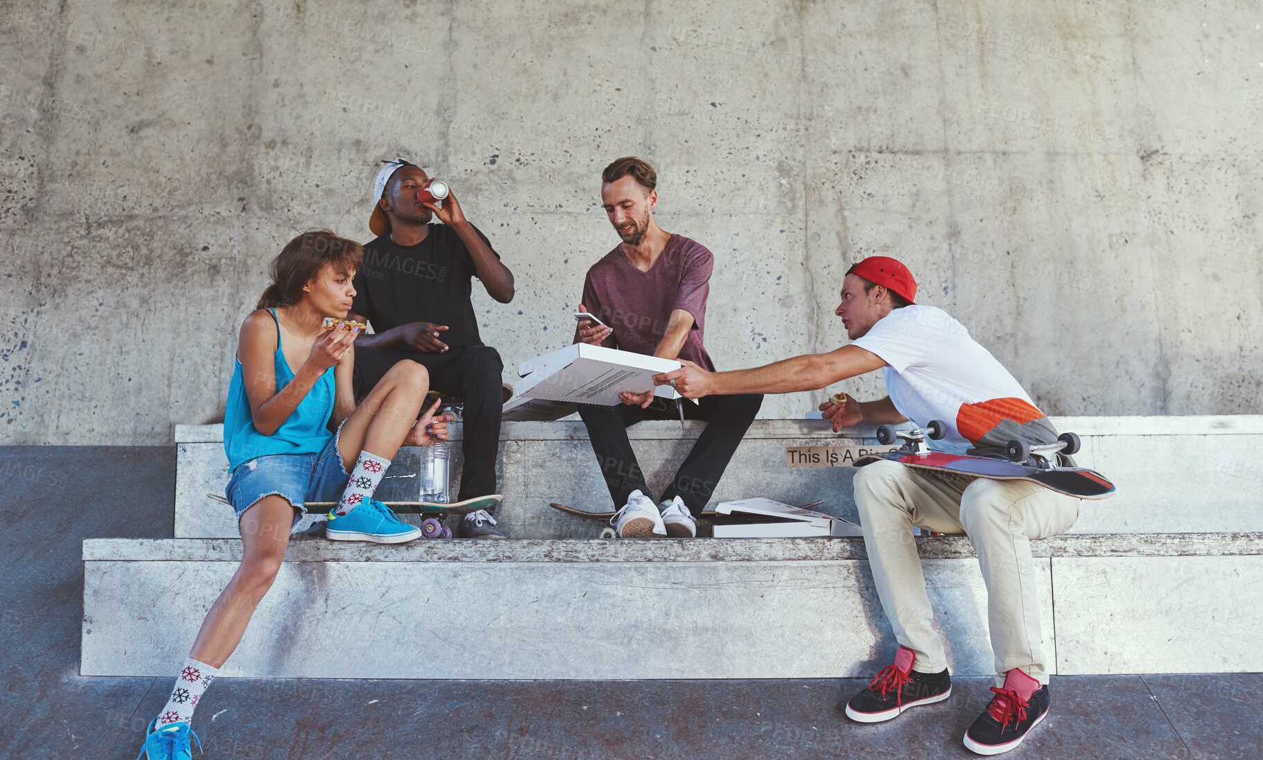 Buy stock photo Shot of a group of skaters having lunch together
