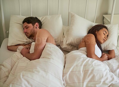 Buy stock photo Shot of a young couple sleeping on opposite sides of the bed at home
