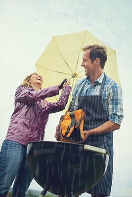 Buy stock photo Man, woman and outdoor for bbq in rain with umbrella, charcoal and surprise on vacation in low angle. Couple, outdoor and grill in storm, cooking and insurance in winter with comic laughing in garden