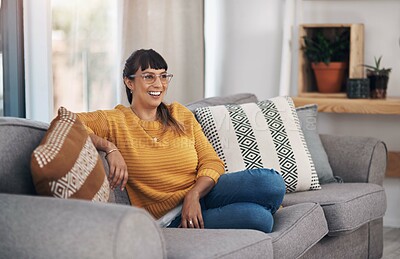 Buy stock photo Cropped shot of an attractive young woman sitting alone in her living room during a day off