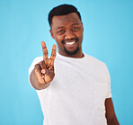 African man, peace sign and studio portrait for smile, vote and victory in review, choice and like by blue background. Person, hand and emoji for feedback, happy or decision with icon, symbol and v