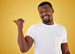 Man, portrait and smile or pointing in studio on yellow background, mockup space for choice information. Black person, face with hand gesture for decision show launch, promo deal or offer opinion