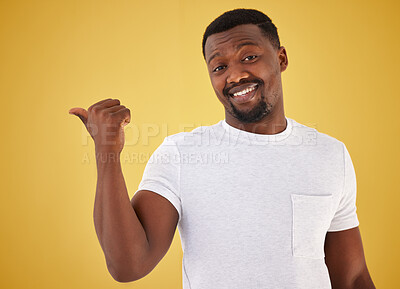 Buy stock photo Man, portrait and smile or pointing in studio on yellow background, mockup space for choice information. Black person, face with hand gesture for decision show launch, promo deal or offer opinion