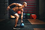 Fitness, weightlifting and black man with kettlebell in gym training for competition, health and body wellness. Sports, workout and exercise, African American athlete lifting with power and strength.