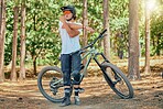 Mountain bike, man stretching in forest and outdoor, ready for cycling and extreme sports, helmet and goggles for safety. Fitness, warm up and riding in nature with bicycle, male athlete and training