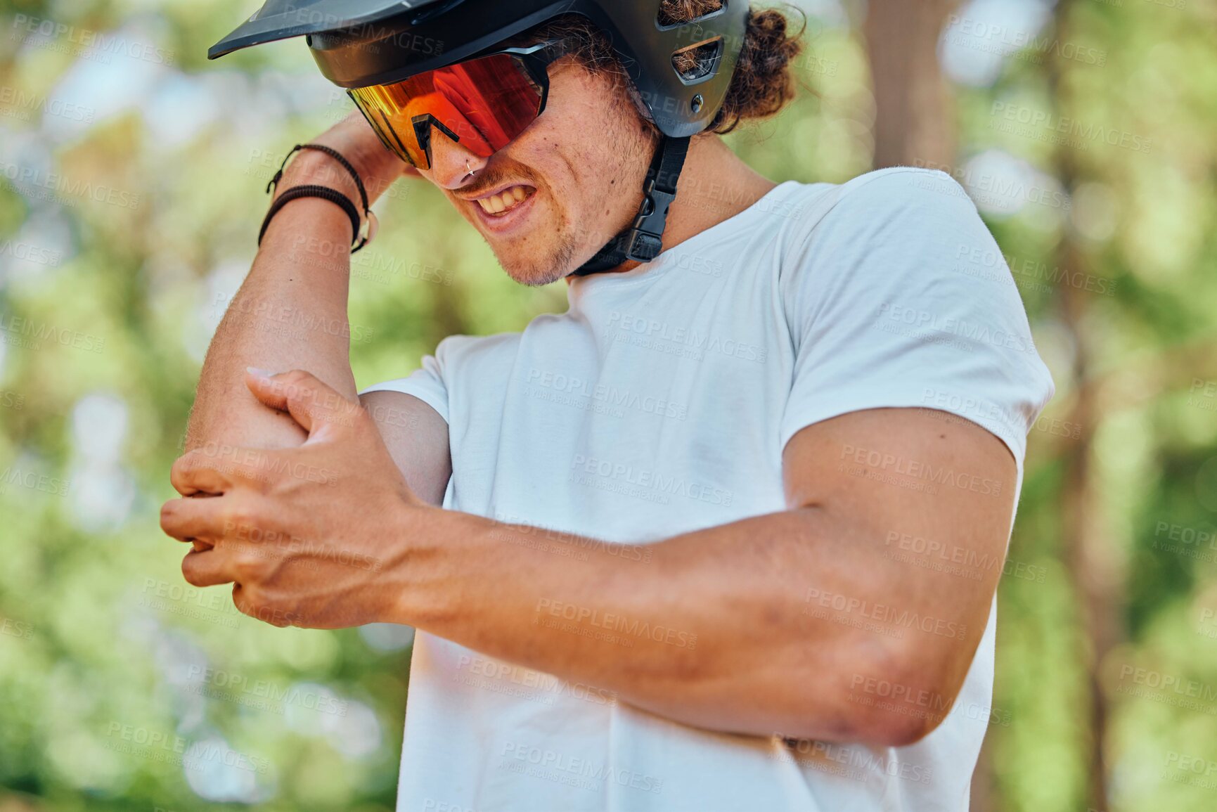 Buy stock photo Sport, injury and man with arm pain, problem or issue while cycling in a forest on blurred background. Injured, elbow and male cyclist suffering inflammation, arthritis or joint ache during exercise