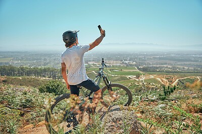 Fitness, cycling and man on a bicycle with phone for selfie, photography or photo in nature. Cyclist, workout and social media health influencer live streaming for blog, website or profile picture