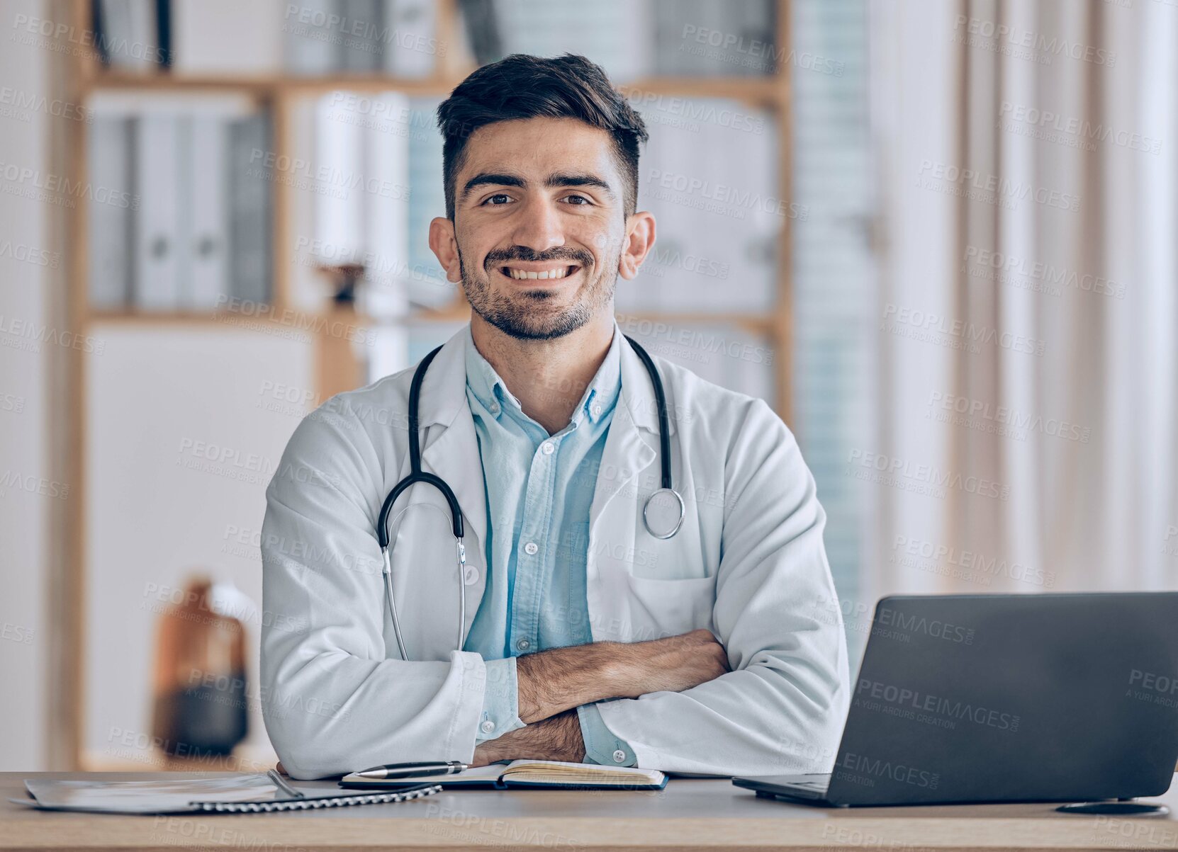 Buy stock photo Happy, portrait and man doctor at desk in a healthcare, medical and hospital office. Smile, male professional and surgeon worker with arms crossed and computer feeling confident and pride in clinic 