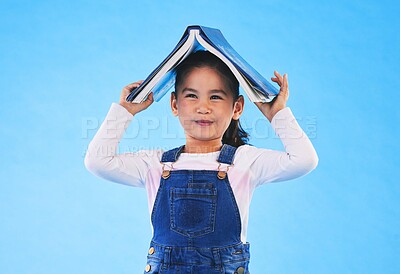 Buy stock photo School, head and portrait of child with book for knowledge or learning isolated in a studio blue background. Clever, smart and young girl kid with notebook happy for education, story or reading