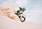 Desert, motorbike and person with sports, ride and journey with freedom, training for competition and challenge. Outdoor, driver and rider practice, extreme action and balance on bike on sand dunes