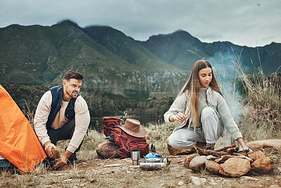 Buy stock photo Couple, camping and pitch tent in nature for vacation, holiday and travel together. Campfire, man and woman outdoor in preparation for adventure, hiking and trekking in the countryside for freedom
