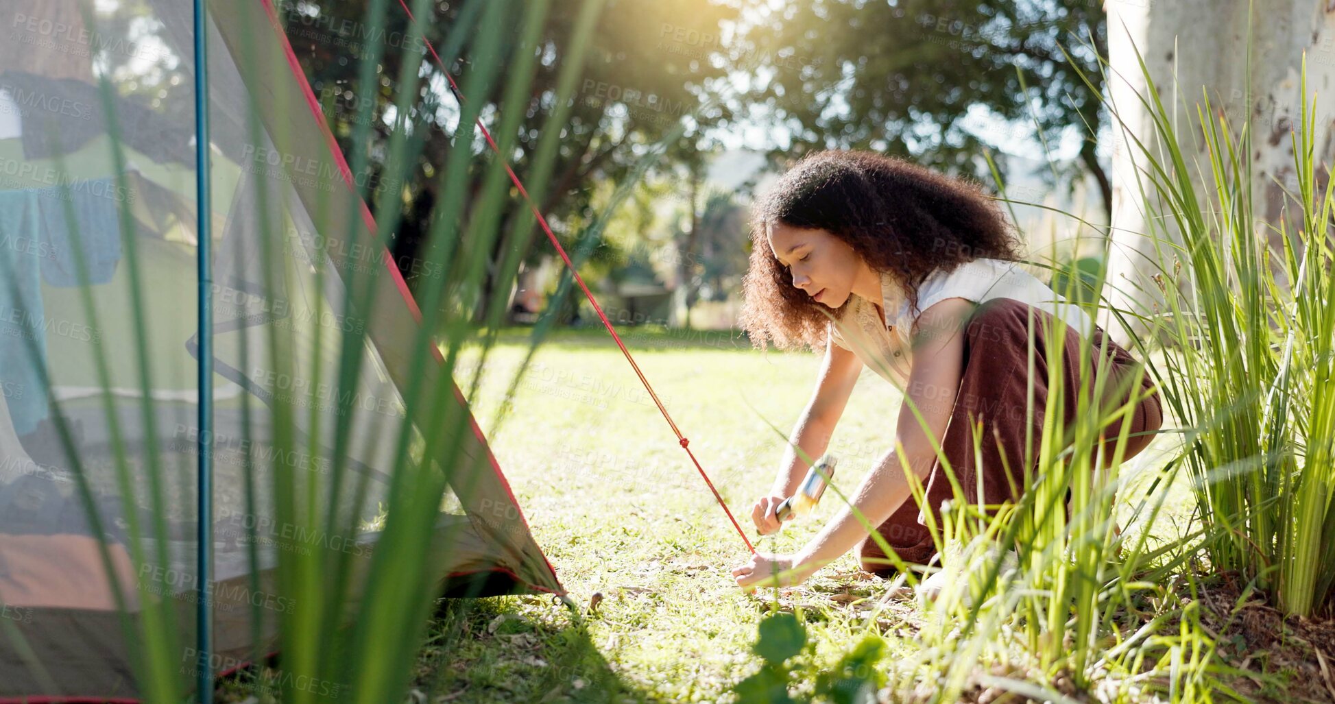 Buy stock photo Tent, nature and woman with a setup for a camp in a forest for holiday or adventure. Vacation, outdoor and a young girl with a hammer for shelter in the woods for a break, trekking or gear in morning