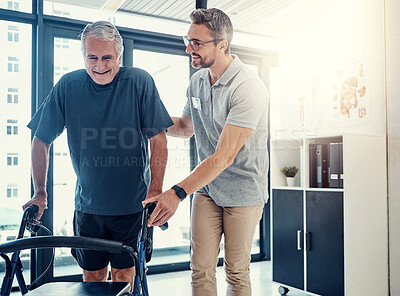 Buy stock photo Shot of a caring physiotherapist helping his mature patient to use a walker at the rehabilitation center