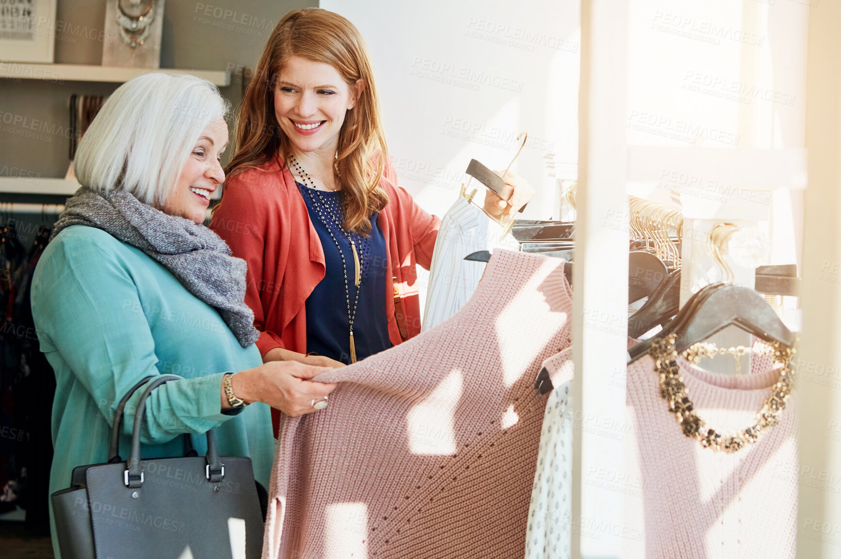 Buy stock photo Shot of a mother and daughter shopping in a clothing store